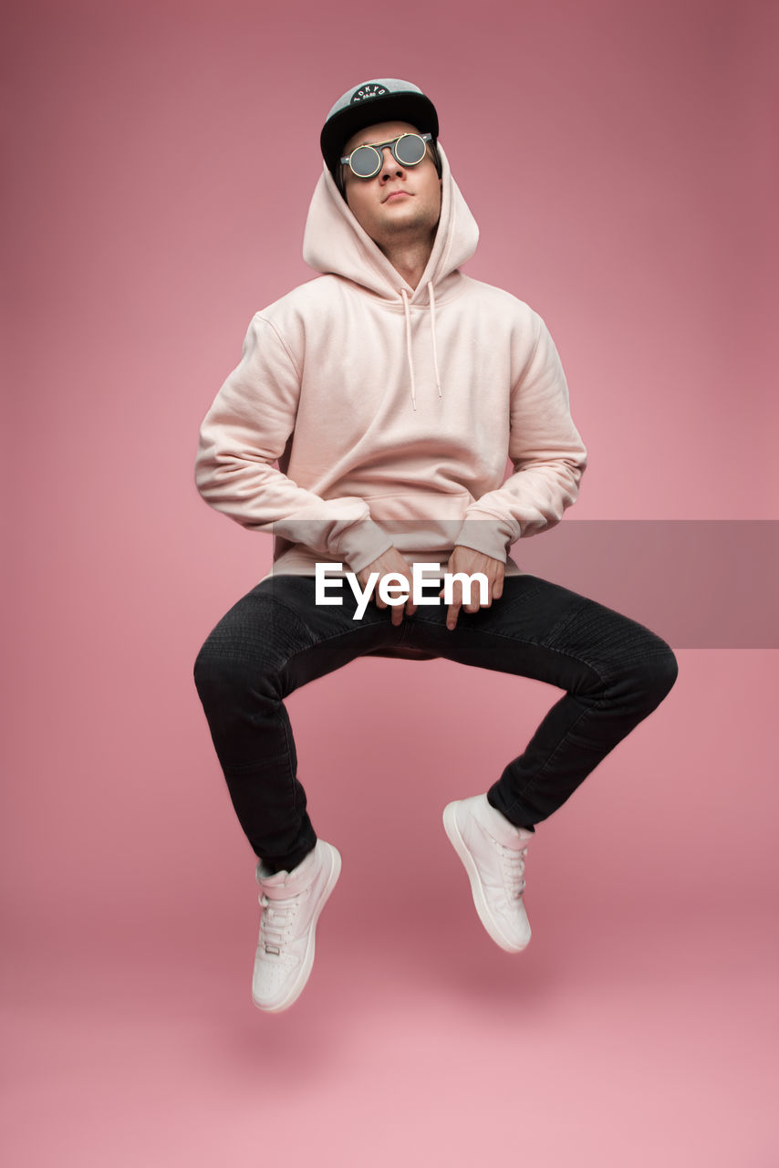 Man in sunglasses against pink background