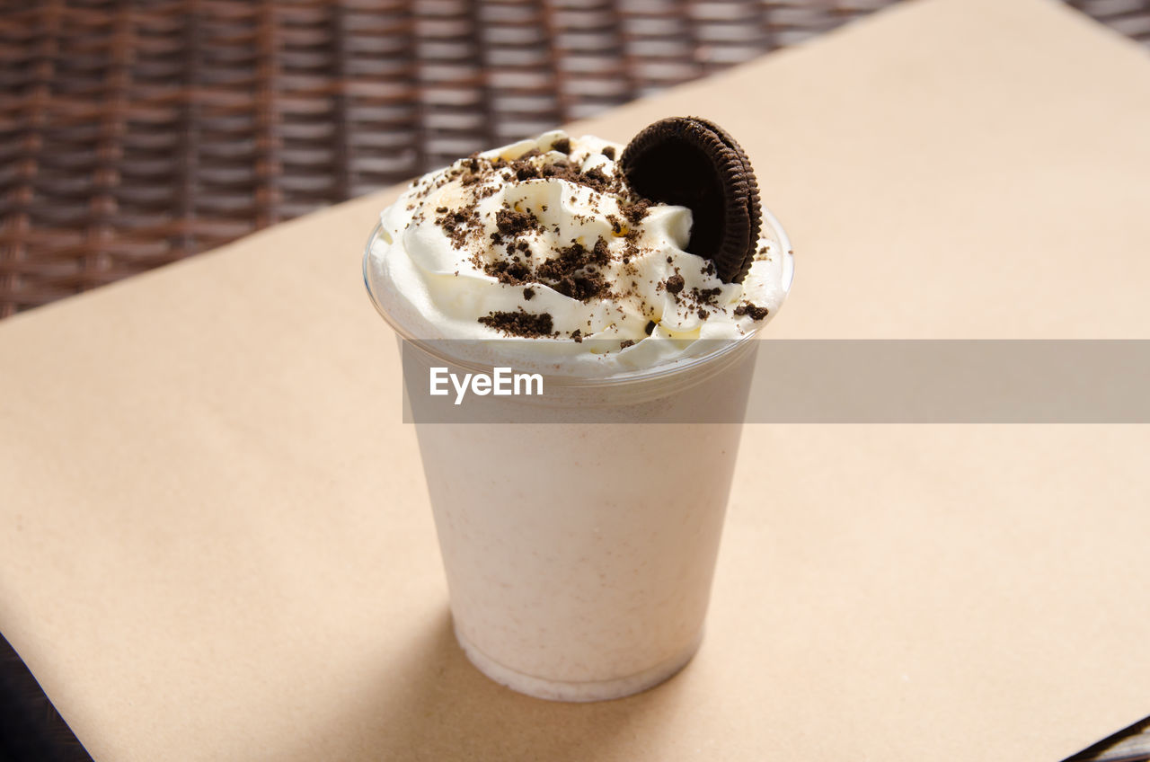 White milkshake with ice cream garnished with cookie.