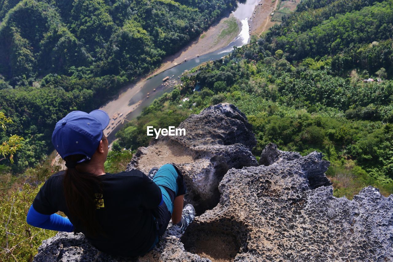 Rear view of woman on cliff looking at river