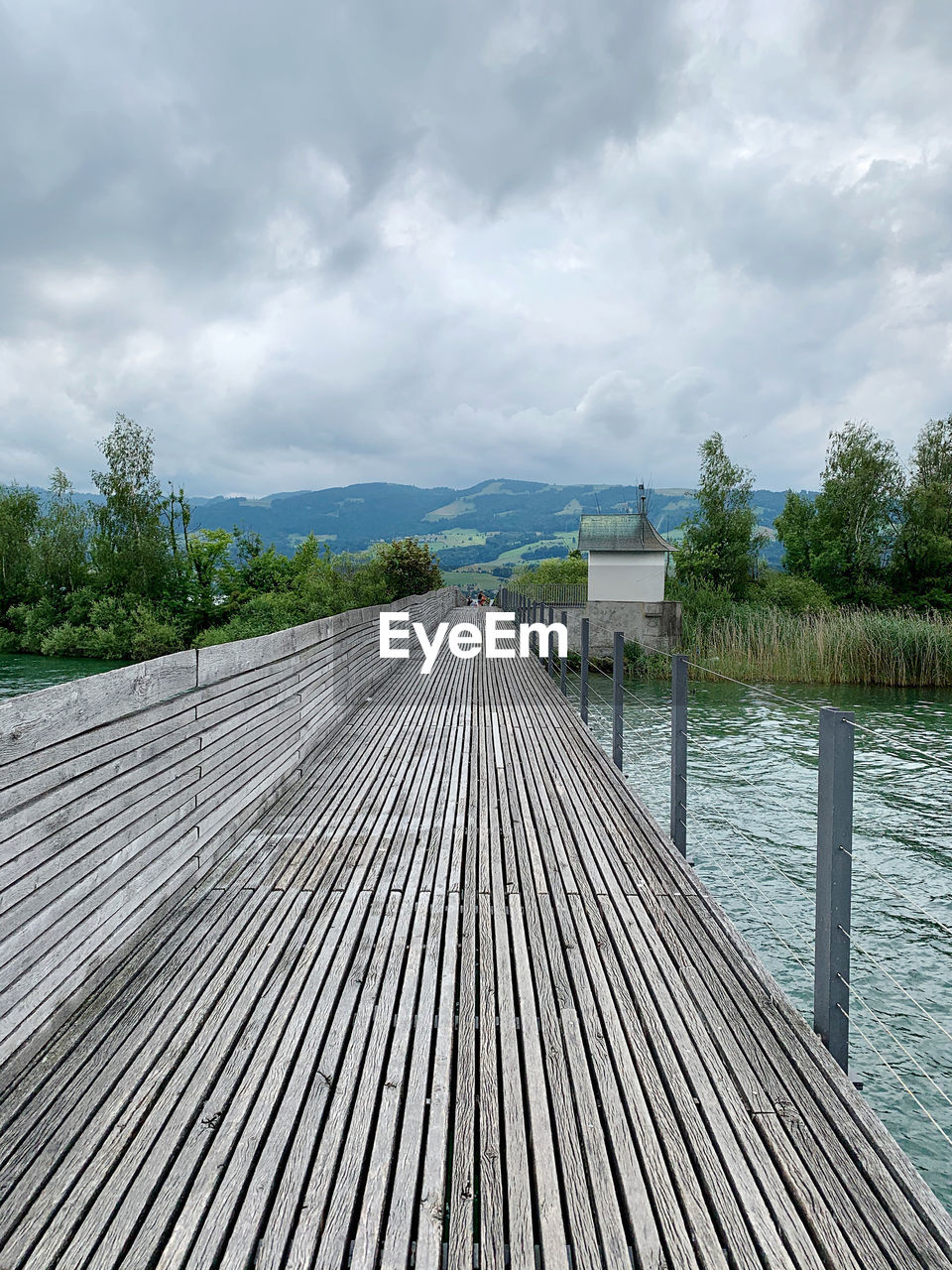 Surface level of boardwalk on pier against sky