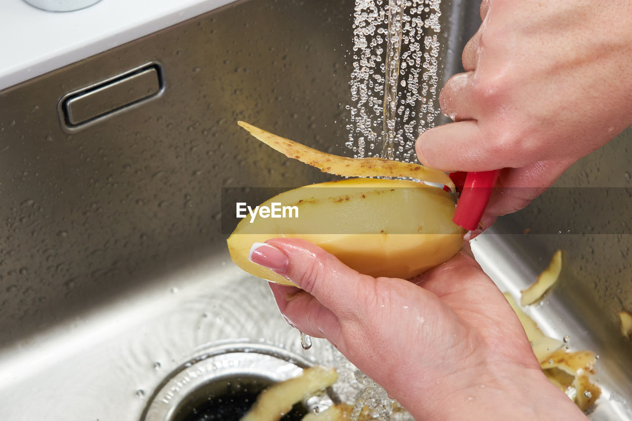 HIGH ANGLE VIEW OF PERSON PREPARING FOOD ON TABLE