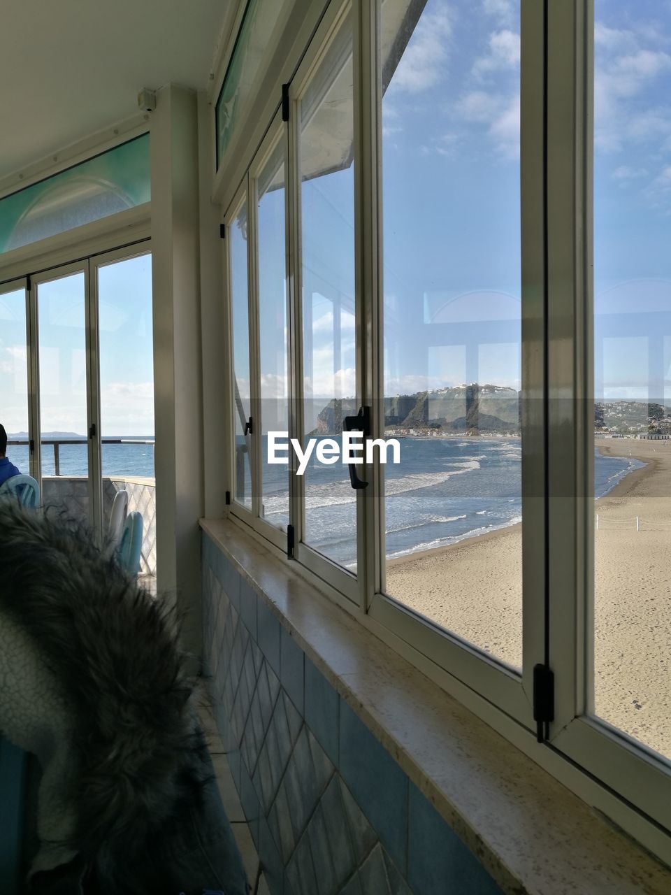 Scenic view of beach against sky seen through glass window