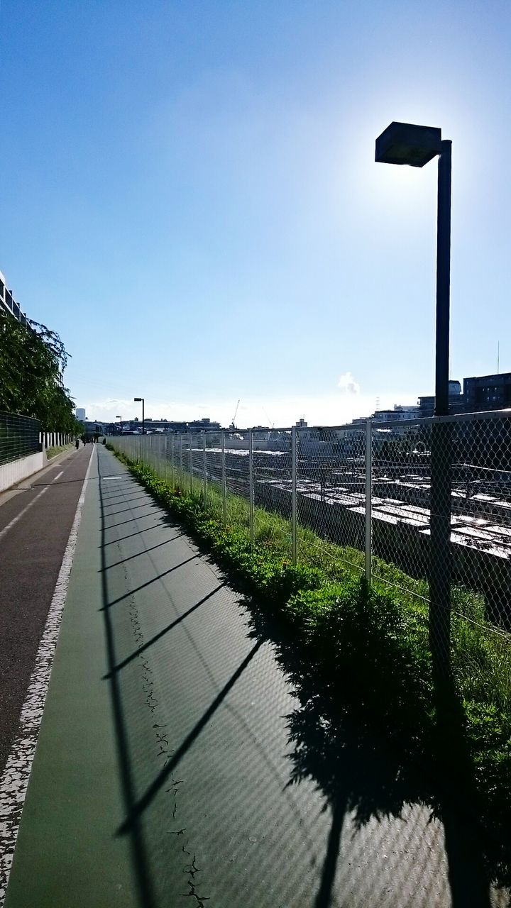 Empty footpath in city against sky