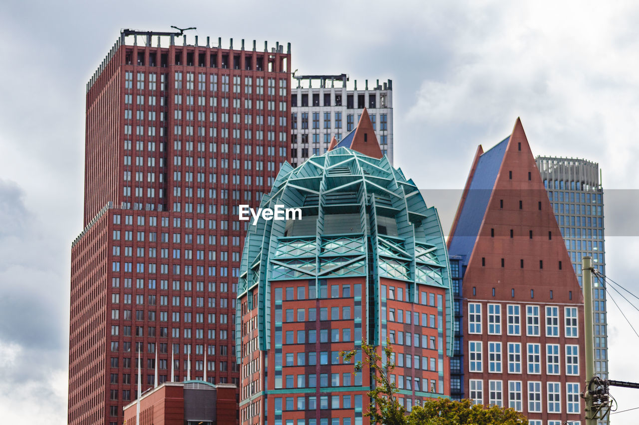 Low angle view of buildings against cloudy sky