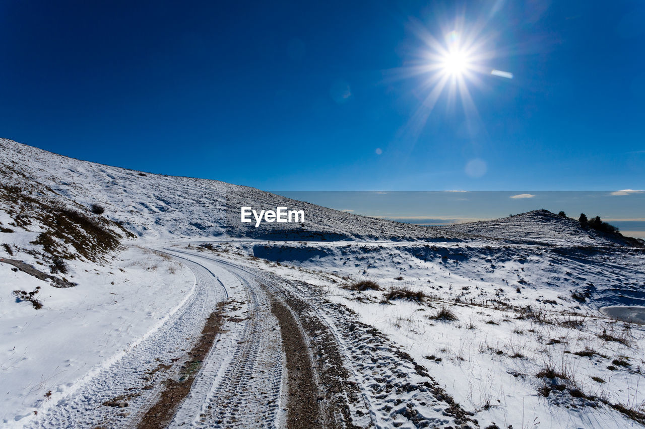 SNOW COVERED MOUNTAINS AGAINST BLUE SKY