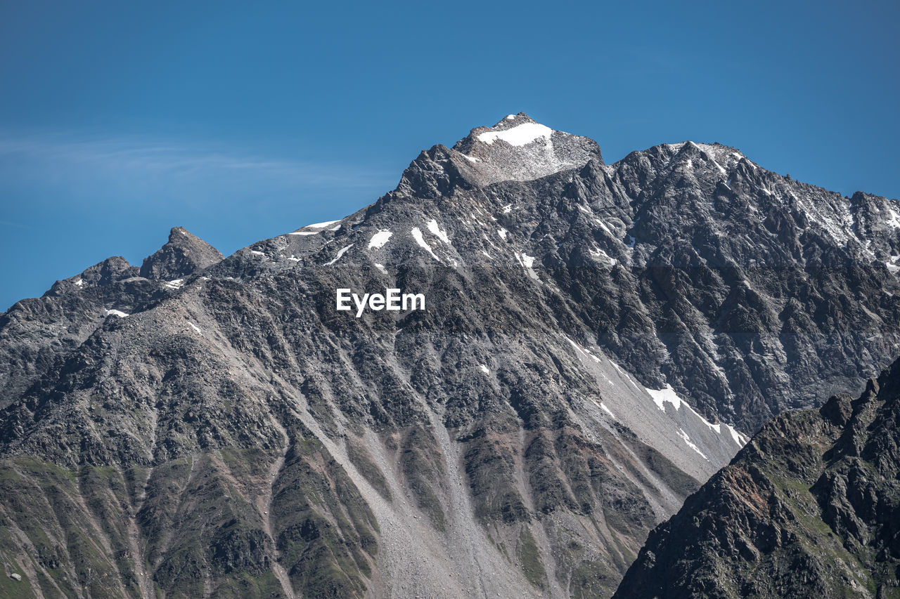 LOW ANGLE VIEW OF MAJESTIC SNOWCAPPED MOUNTAINS AGAINST SKY