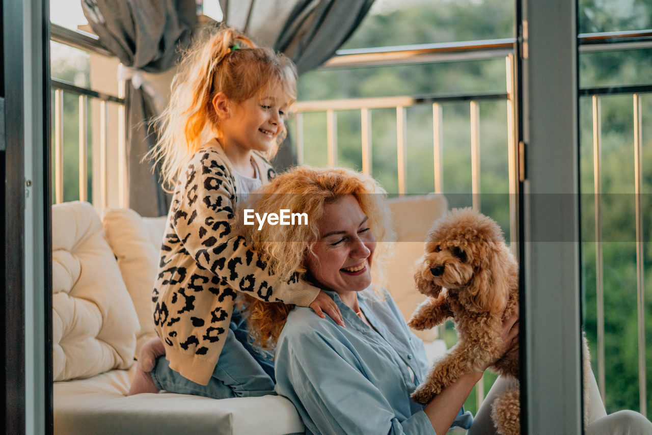 Side view of young woman with dog at home