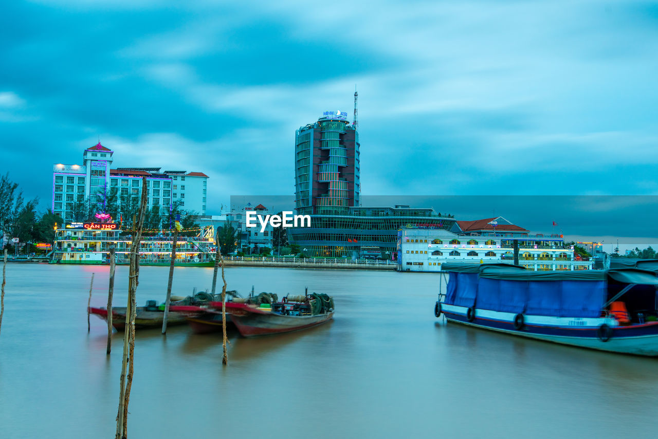 SHIP MOORED AT HARBOR AGAINST BUILDINGS IN CITY