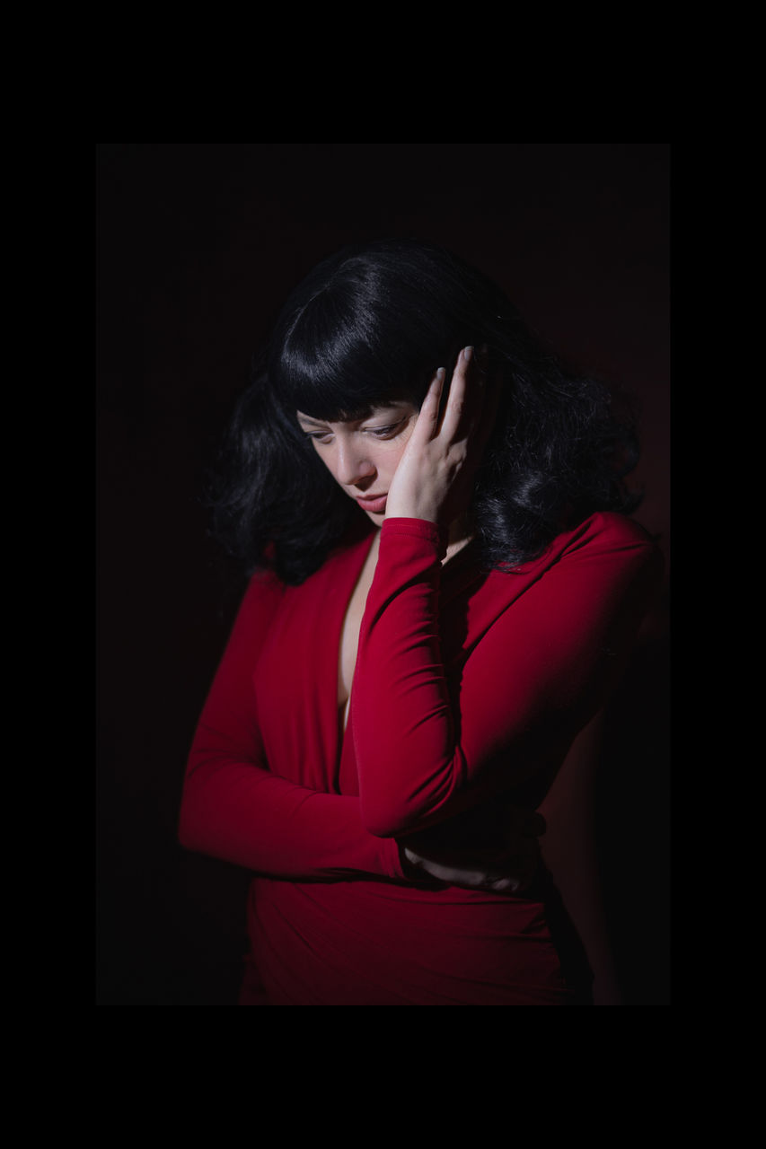 one person, adult, women, indoors, darkness, sadness, studio shot, black background, young adult, red, emotion, depression - sadness, emotional stress, portrait, dark, clothing, hairstyle, waist up, hand, photo shoot, female, negative emotion, person, human mouth, black, black hair, frustration, long hair, head in hands, worried