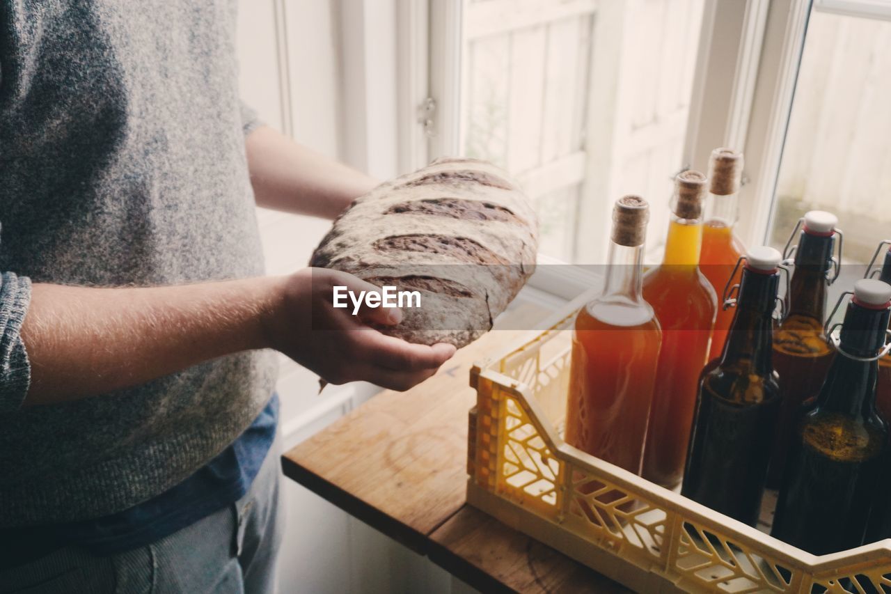 High angel view of hands holding homemade sourdough bread