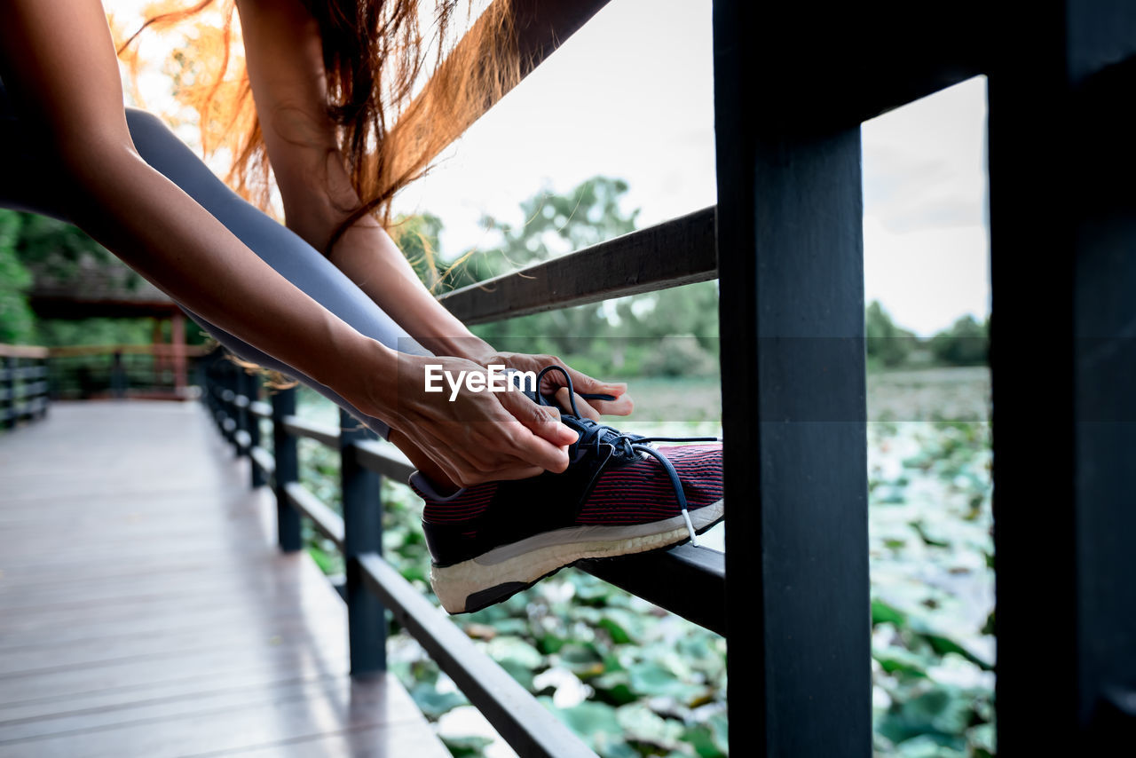 LOW SECTION OF WOMEN HOLDING RAILING