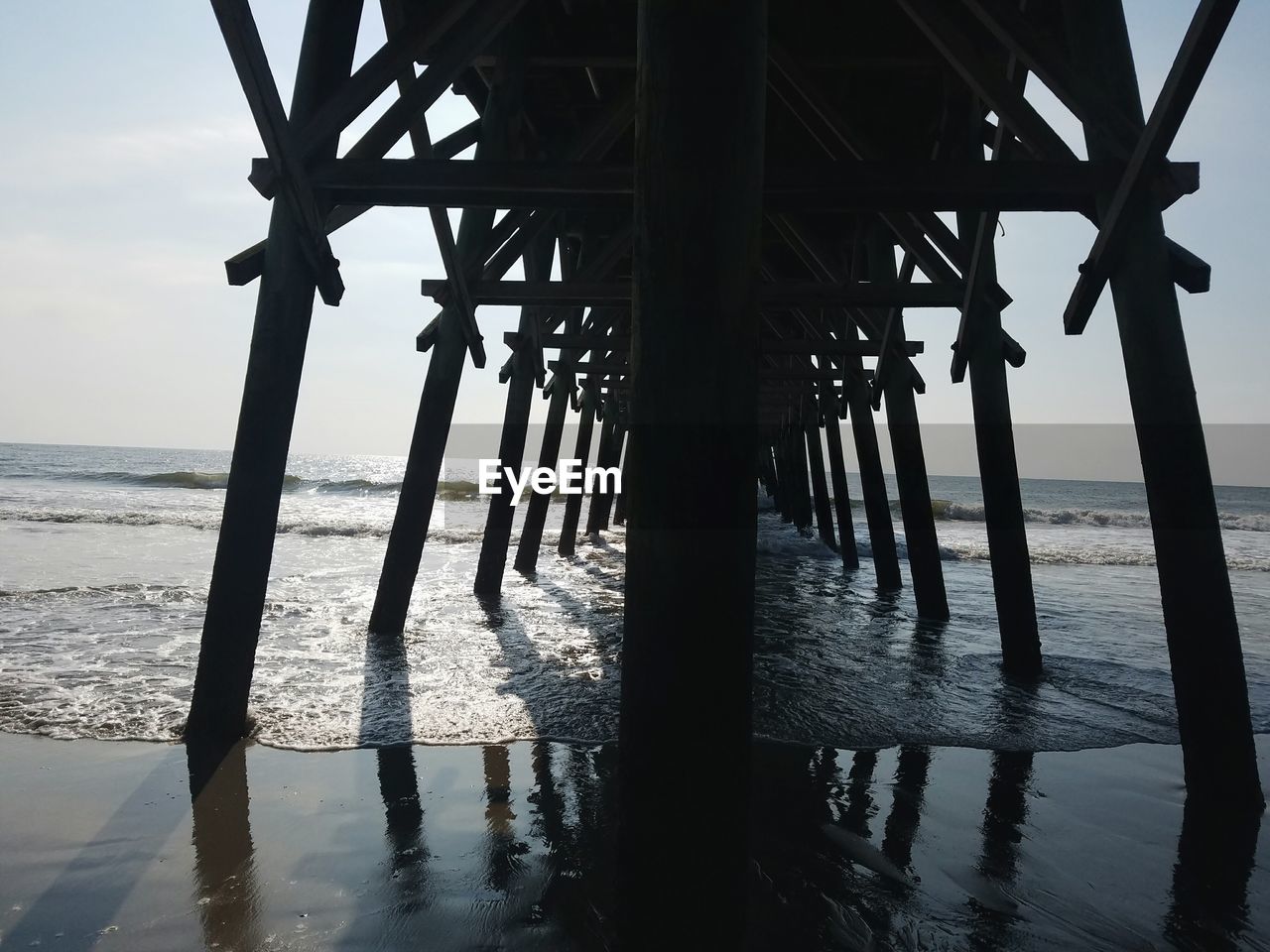 Silhouette of pier on beach