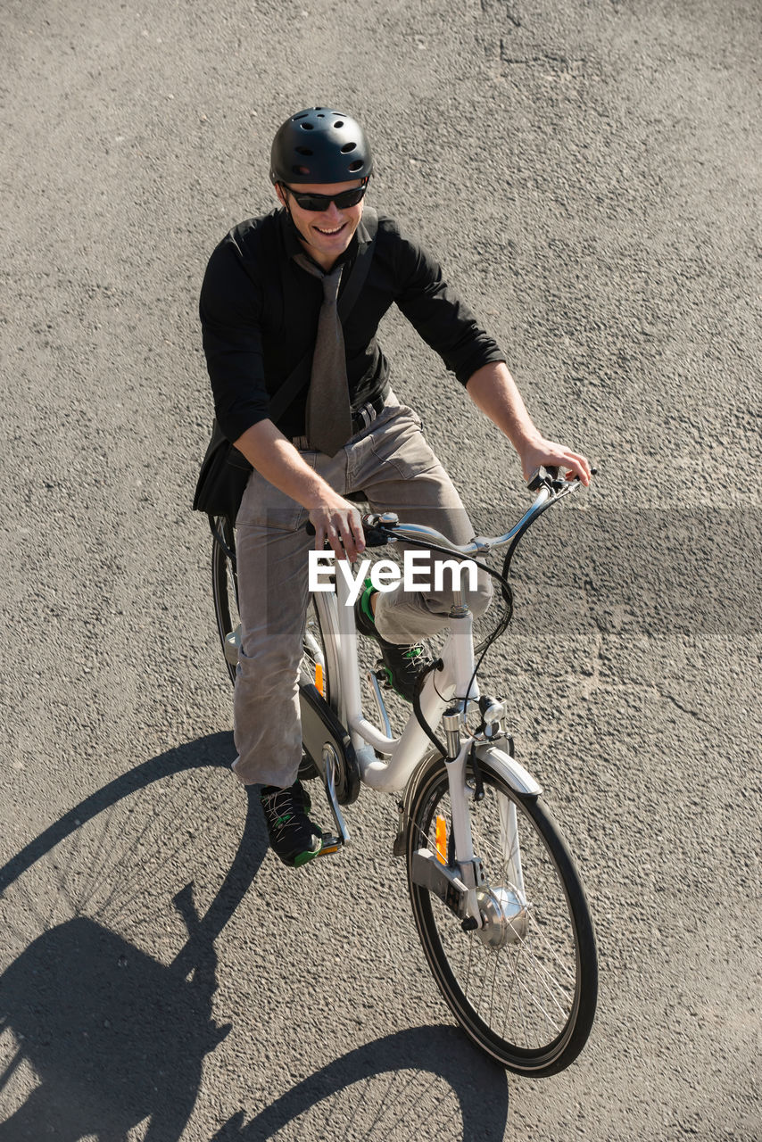 High angle view of businessman riding bicycle on road
