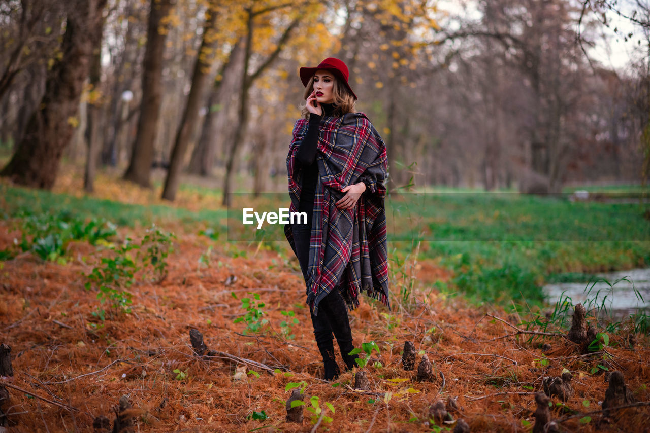 Young woman standing on field in forest