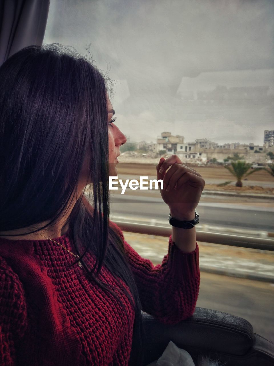 Woman looking through window in bus
