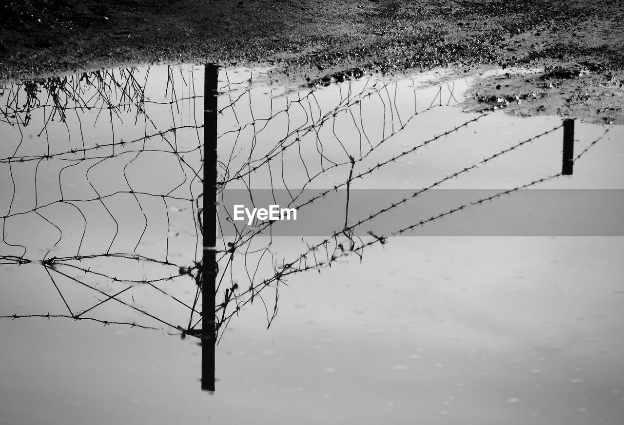 High angle view of barbed wire fence in lake