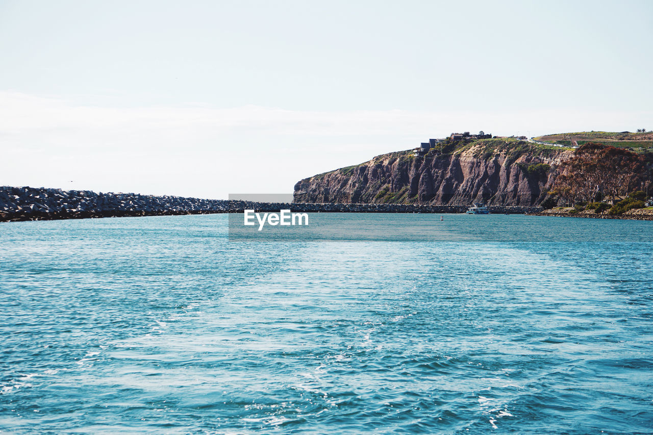 ROCK FORMATIONS IN SEA AGAINST SKY