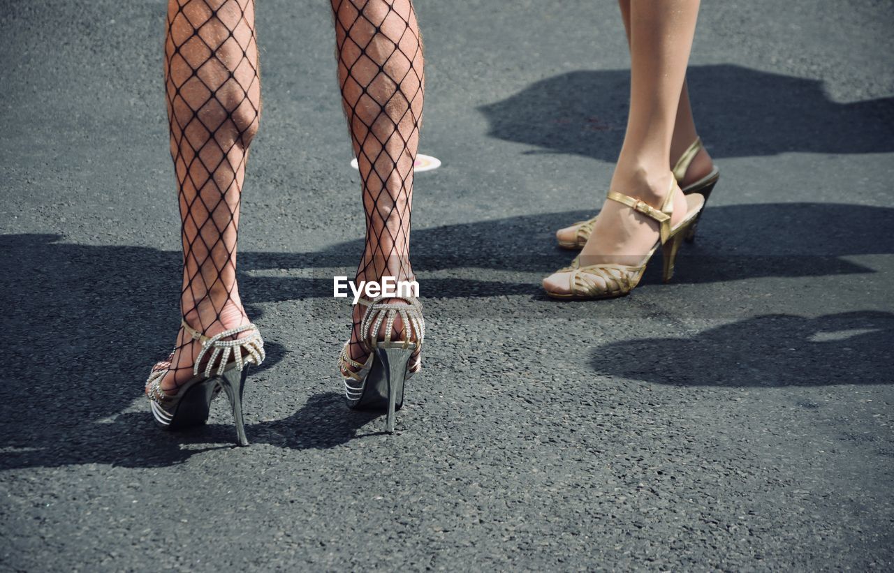 Low section of women standing on road