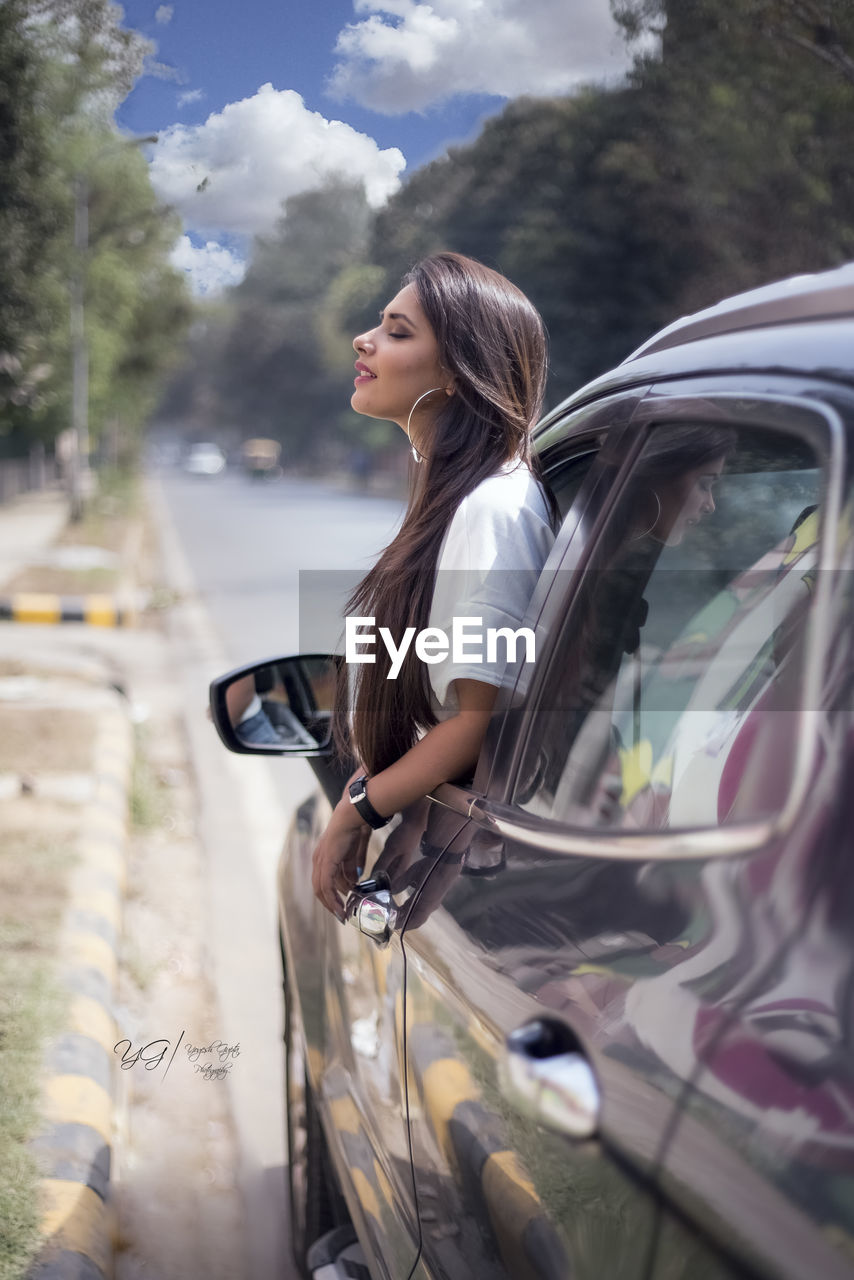 SIDE VIEW OF YOUNG WOMAN LOOKING DOWN