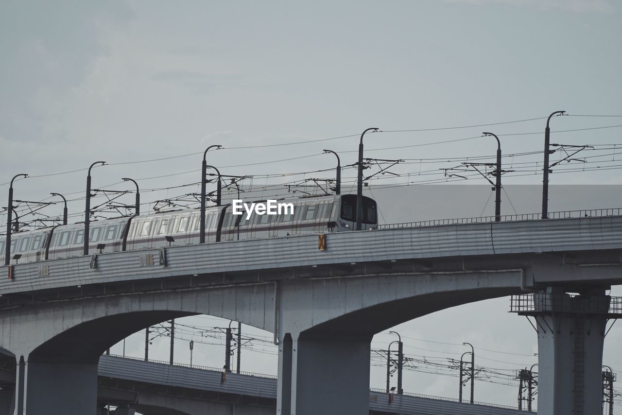 LOW ANGLE VIEW OF RAILWAY BRIDGE AGAINST BUILDINGS