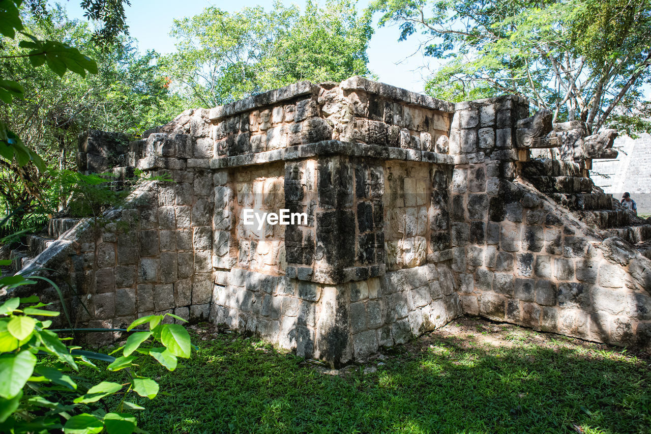 Old ruins by trees during sunny day