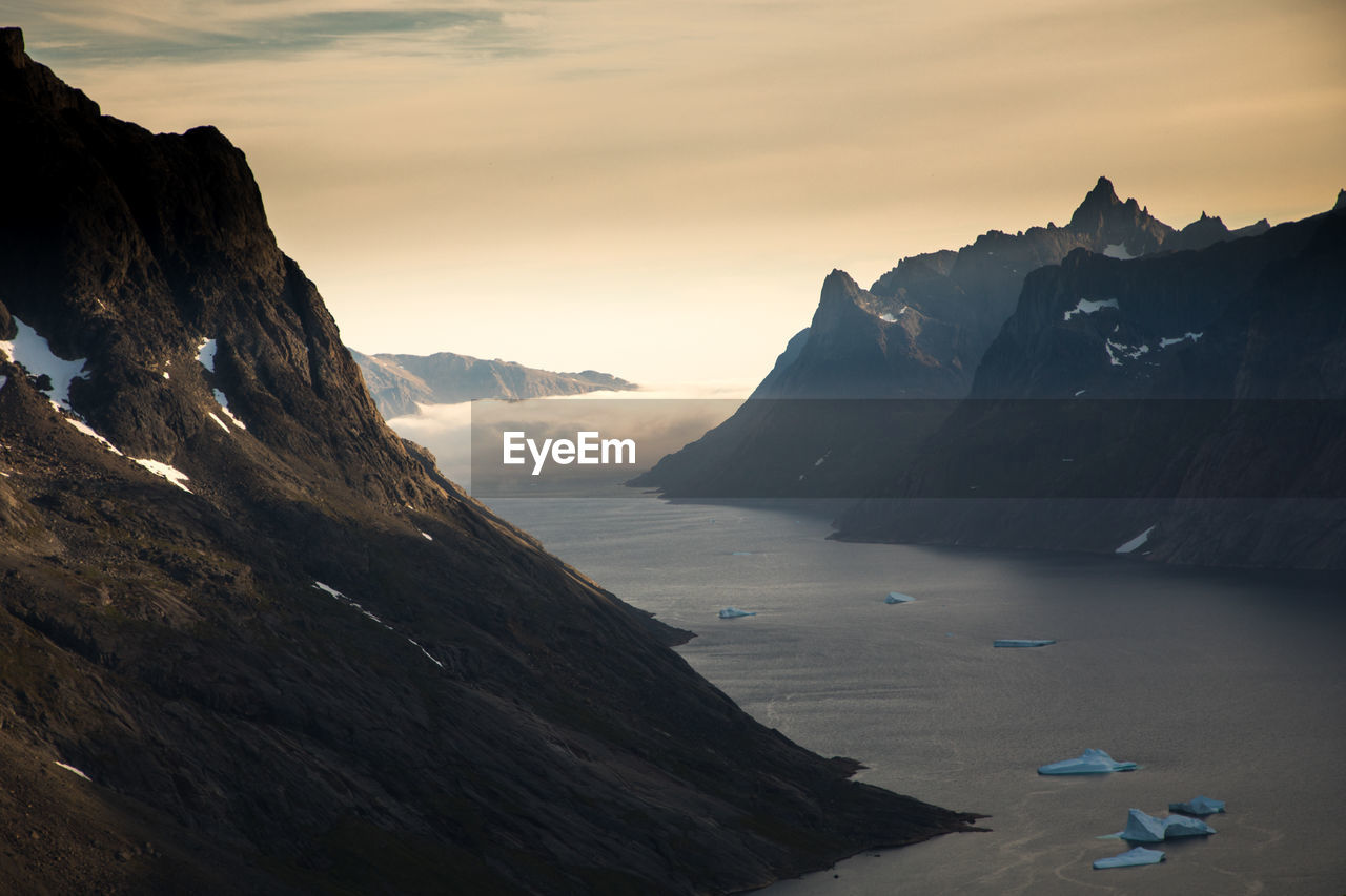 Scenic view of sea and mountains against sky