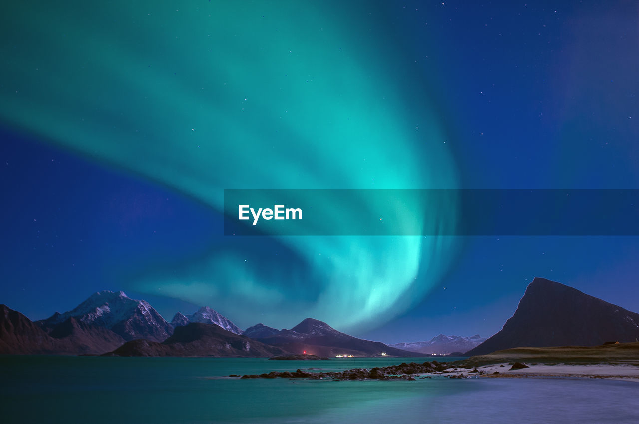 Scenic view of snowcapped mountains against sky at night