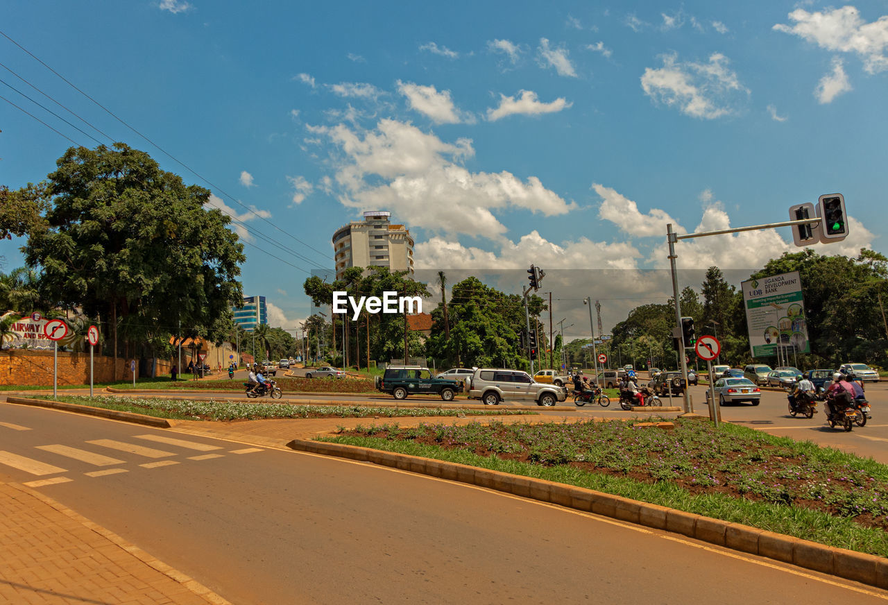 Cars on road in city against sky