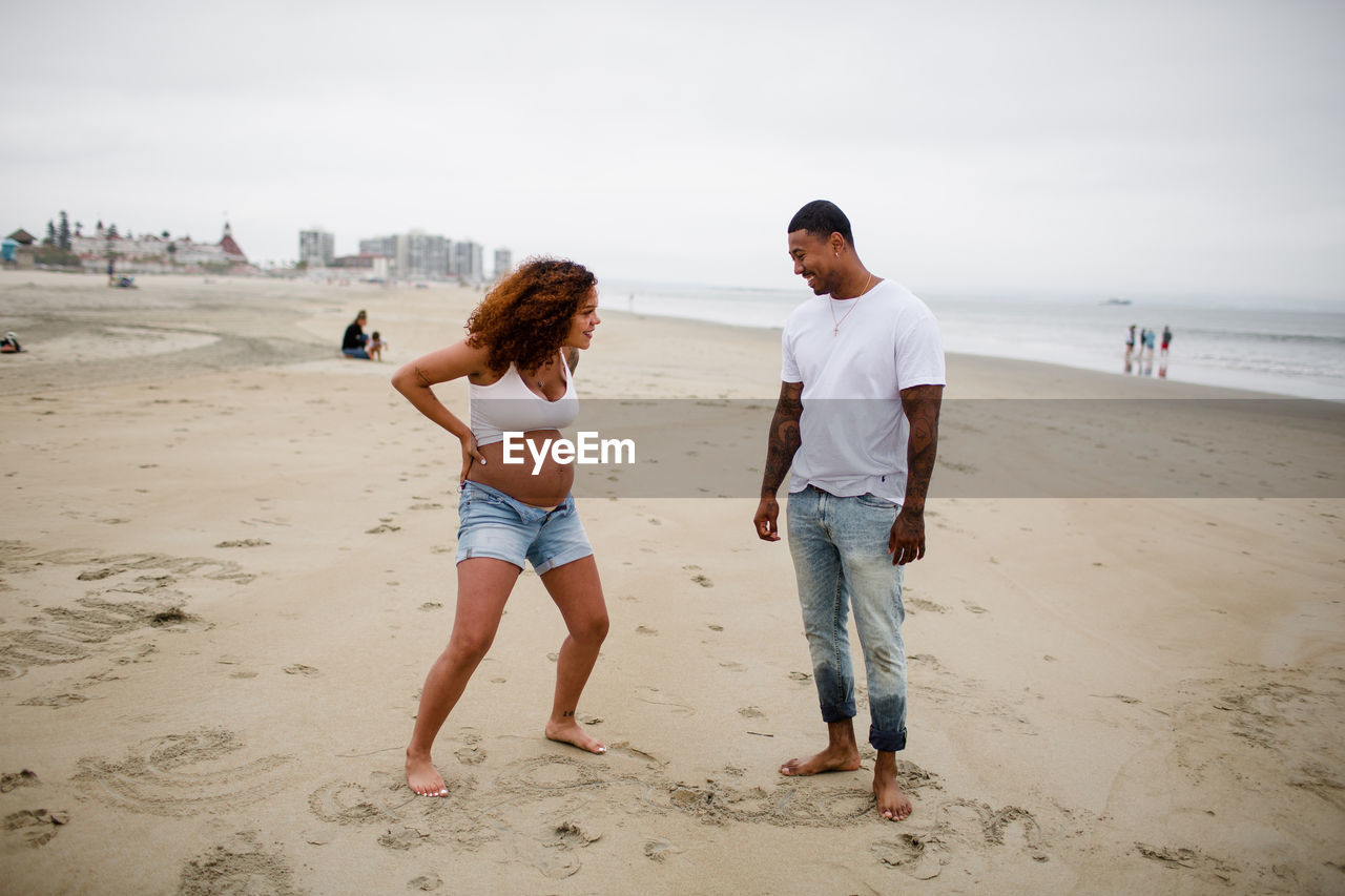 Mixed race couple goofing around on beach