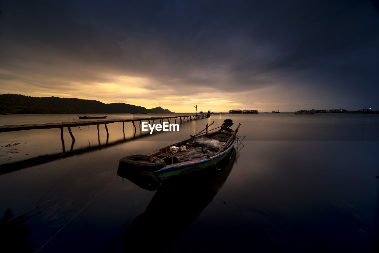 BOAT MOORED IN SEA AGAINST SKY