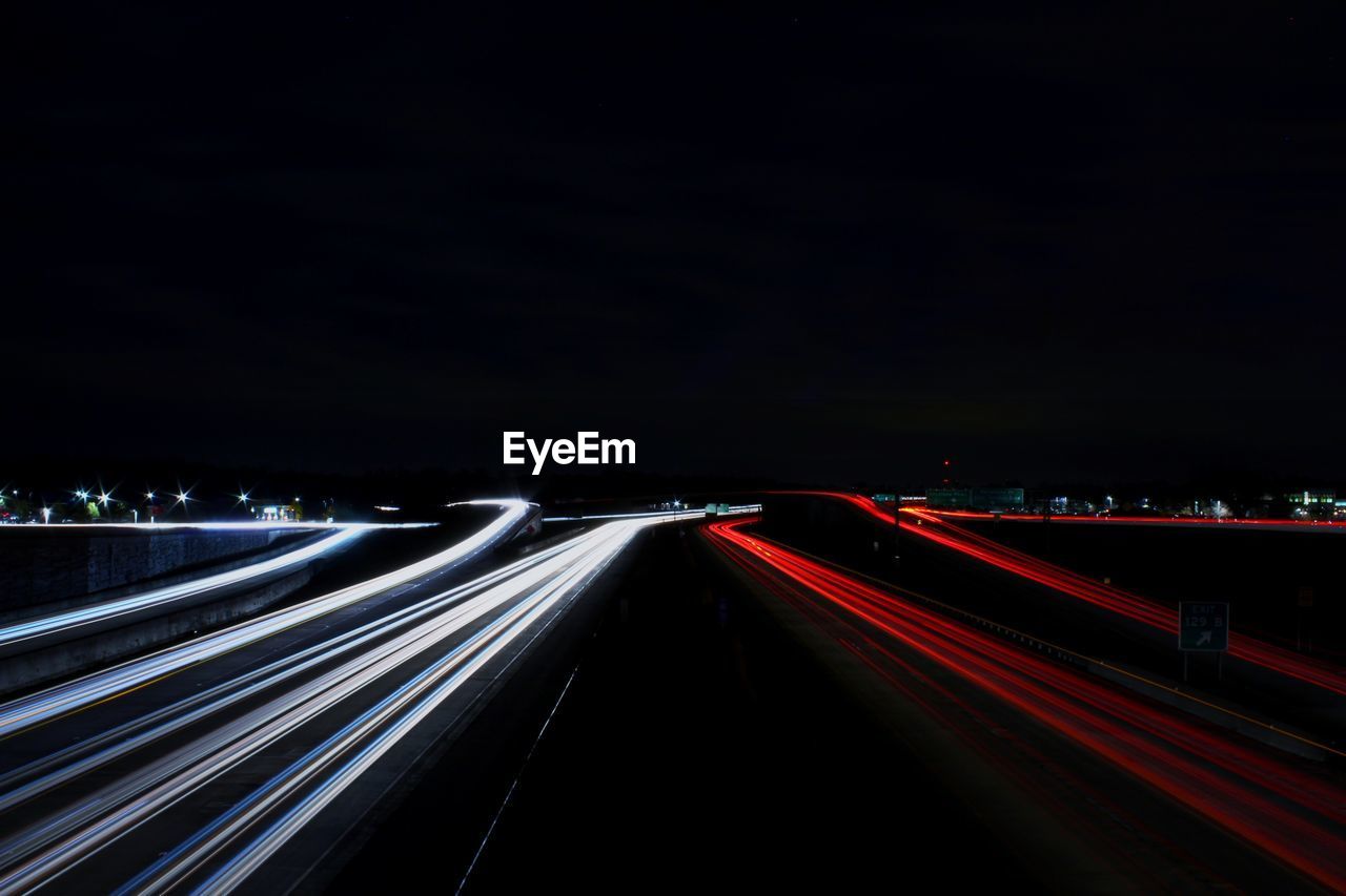 LIGHT TRAILS ON STREET AT NIGHT