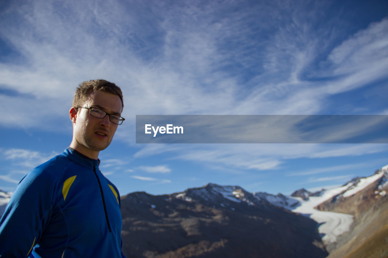 Portrait of man standing against mountains