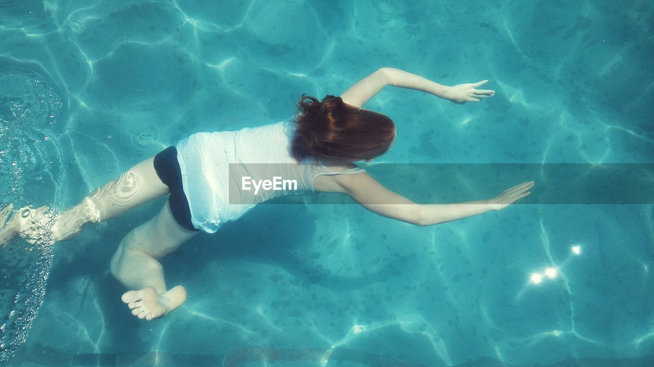 High angle view of woman swimming underwater in swimming pool