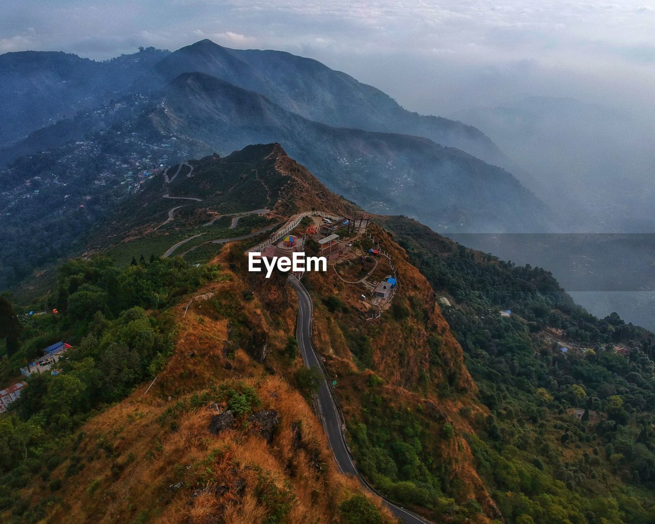 Aerial view of building on hill against mountains