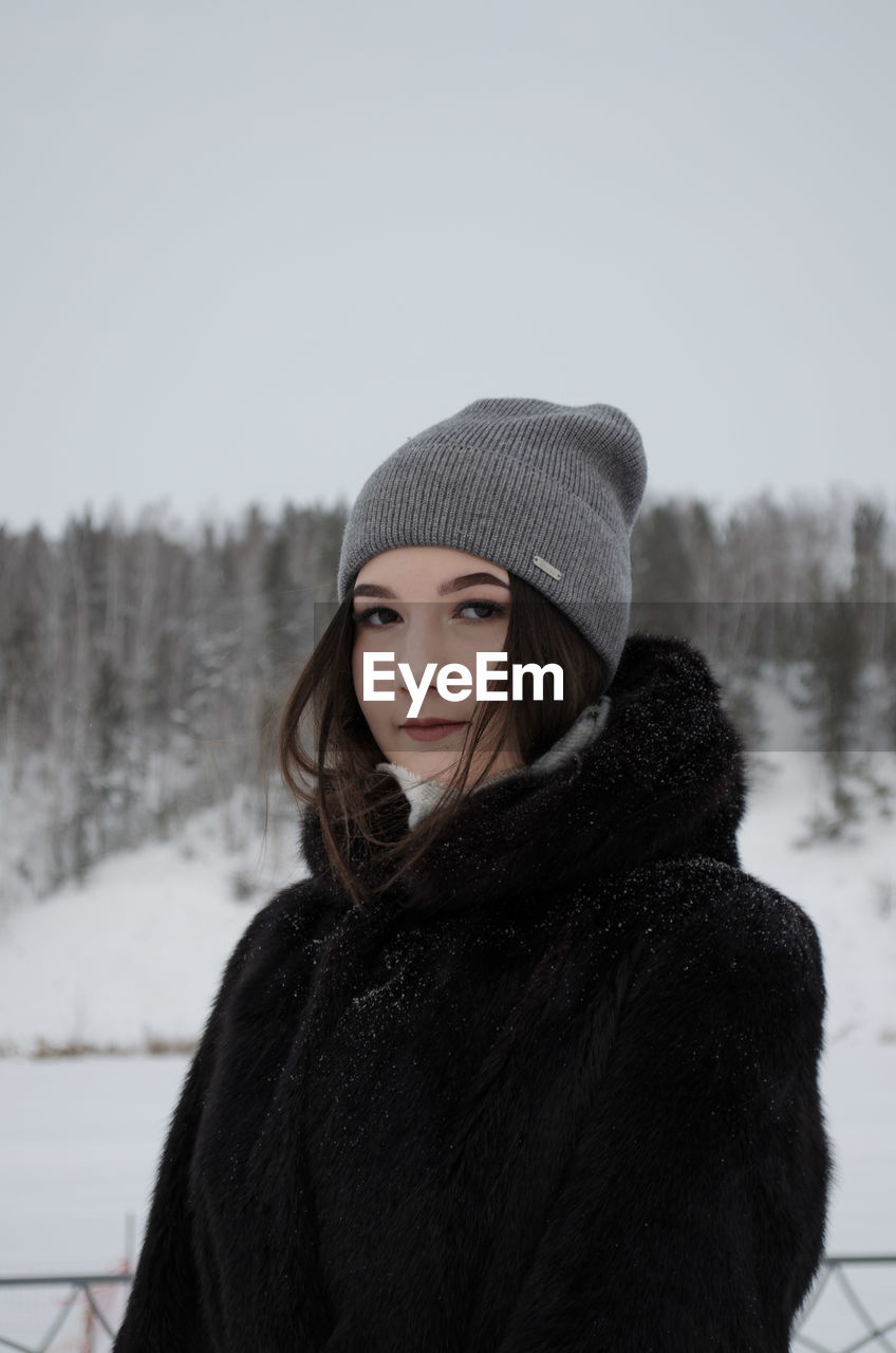 Portrait of young woman standing in snow