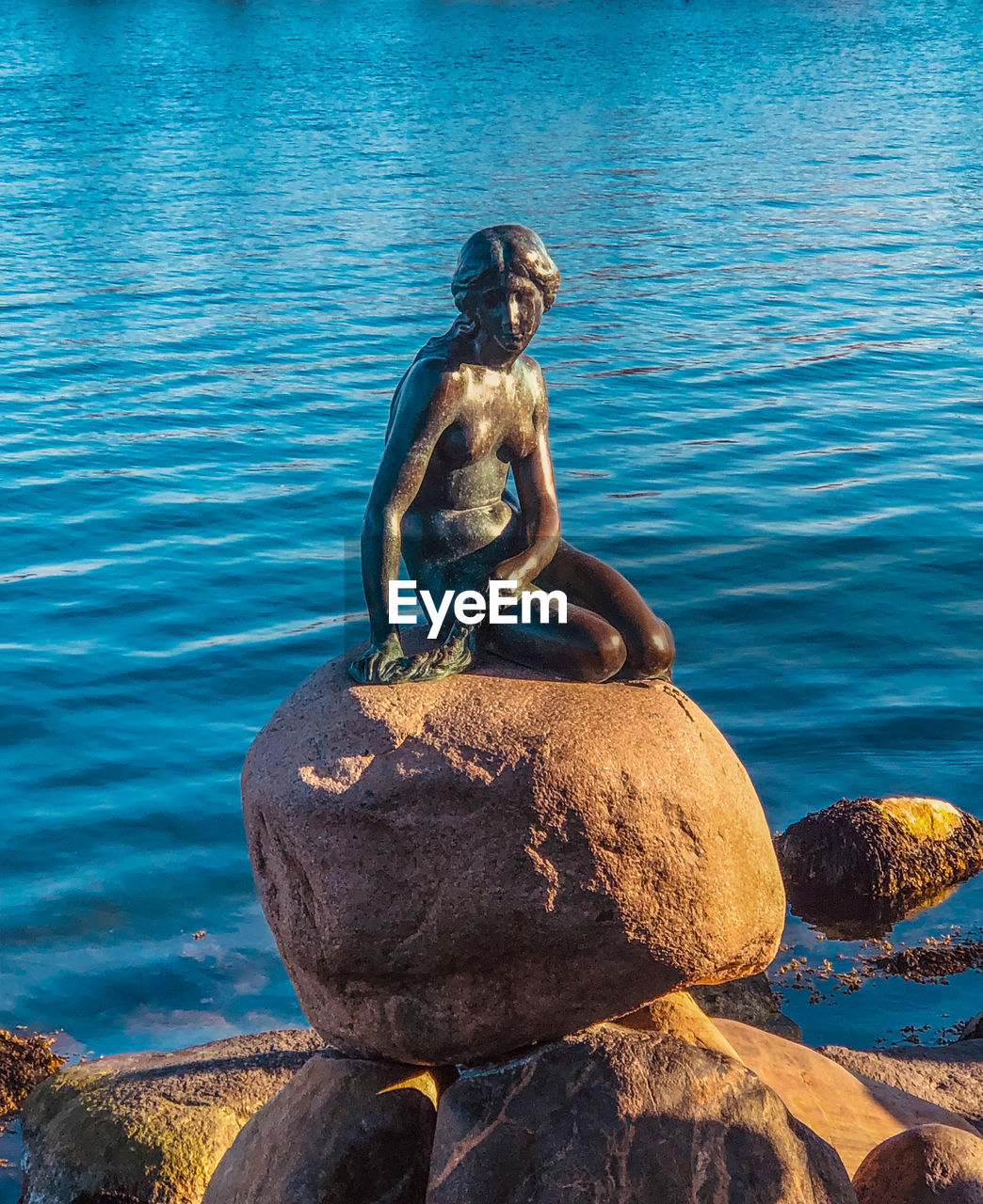 FULL LENGTH OF MAN SITTING ON ROCK