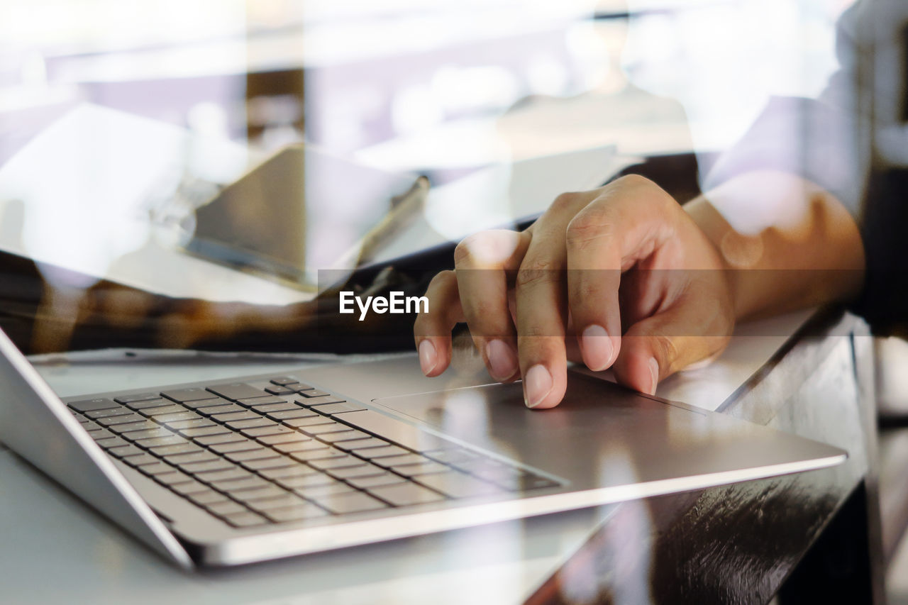 Close up image of man typing on laptop keyboard