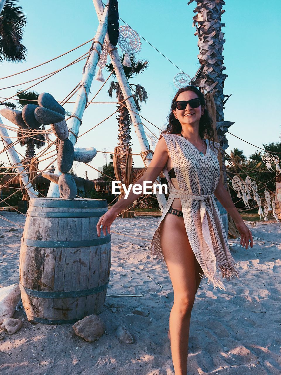 Young woman wearing sunglasses while standing at beach