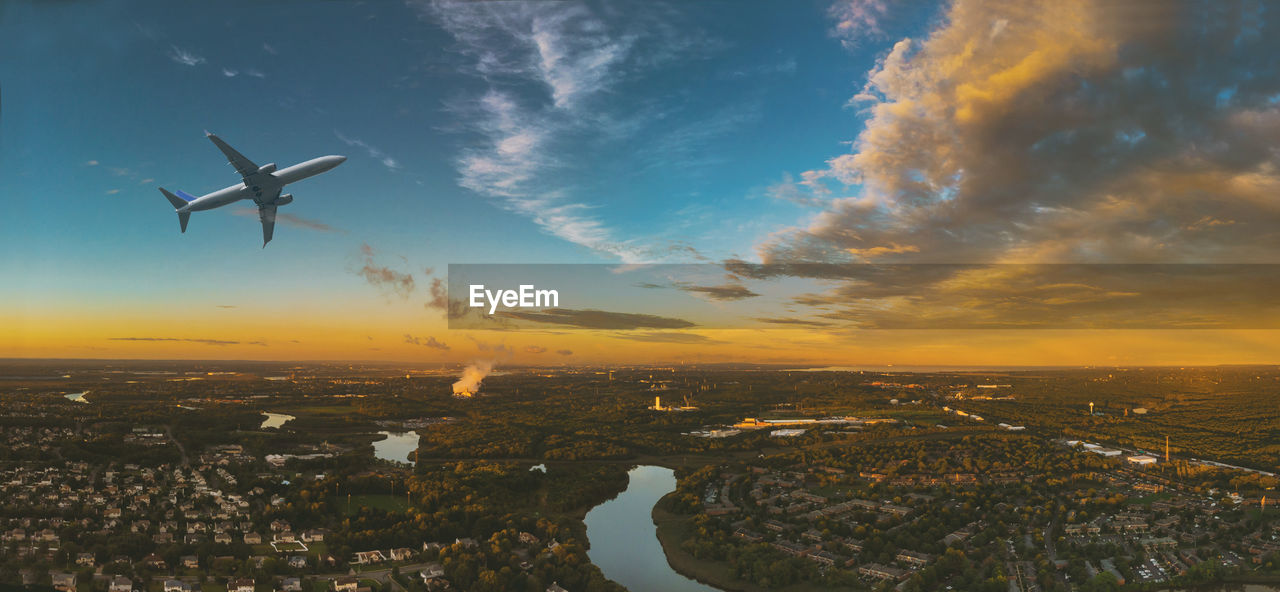 Airplane flying over cityscape against sky