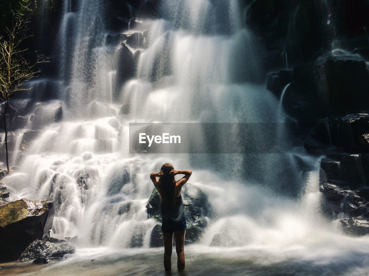 Rear view of woman overlooking waterfall