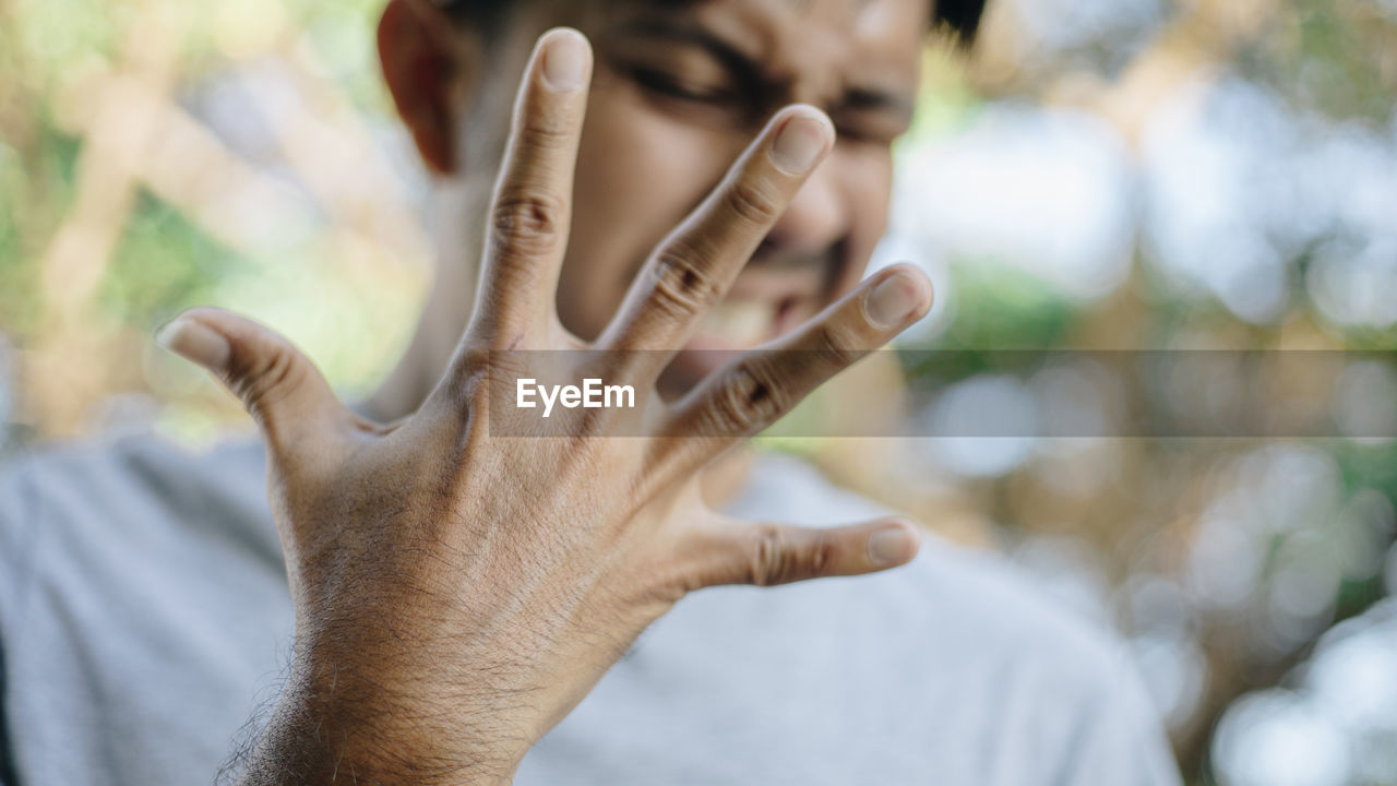 Close-up of man gesturing outdoors