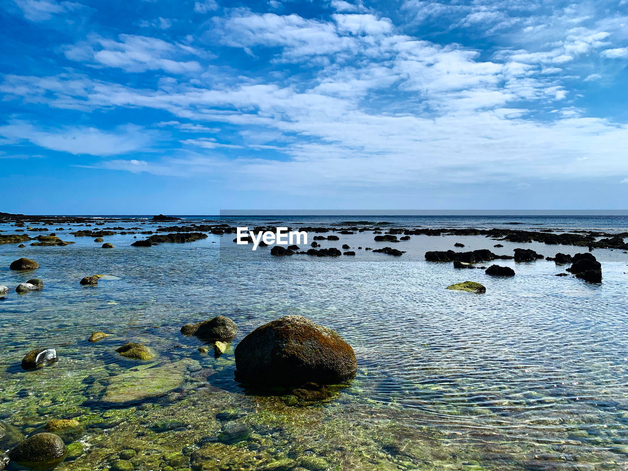 ROCKS IN SEA AGAINST SKY