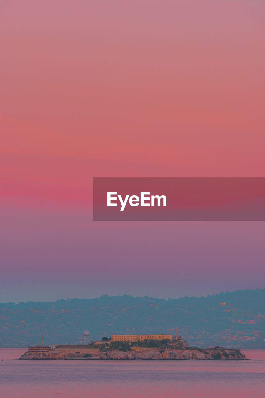 Scenic view of a prison island against sky during sunset