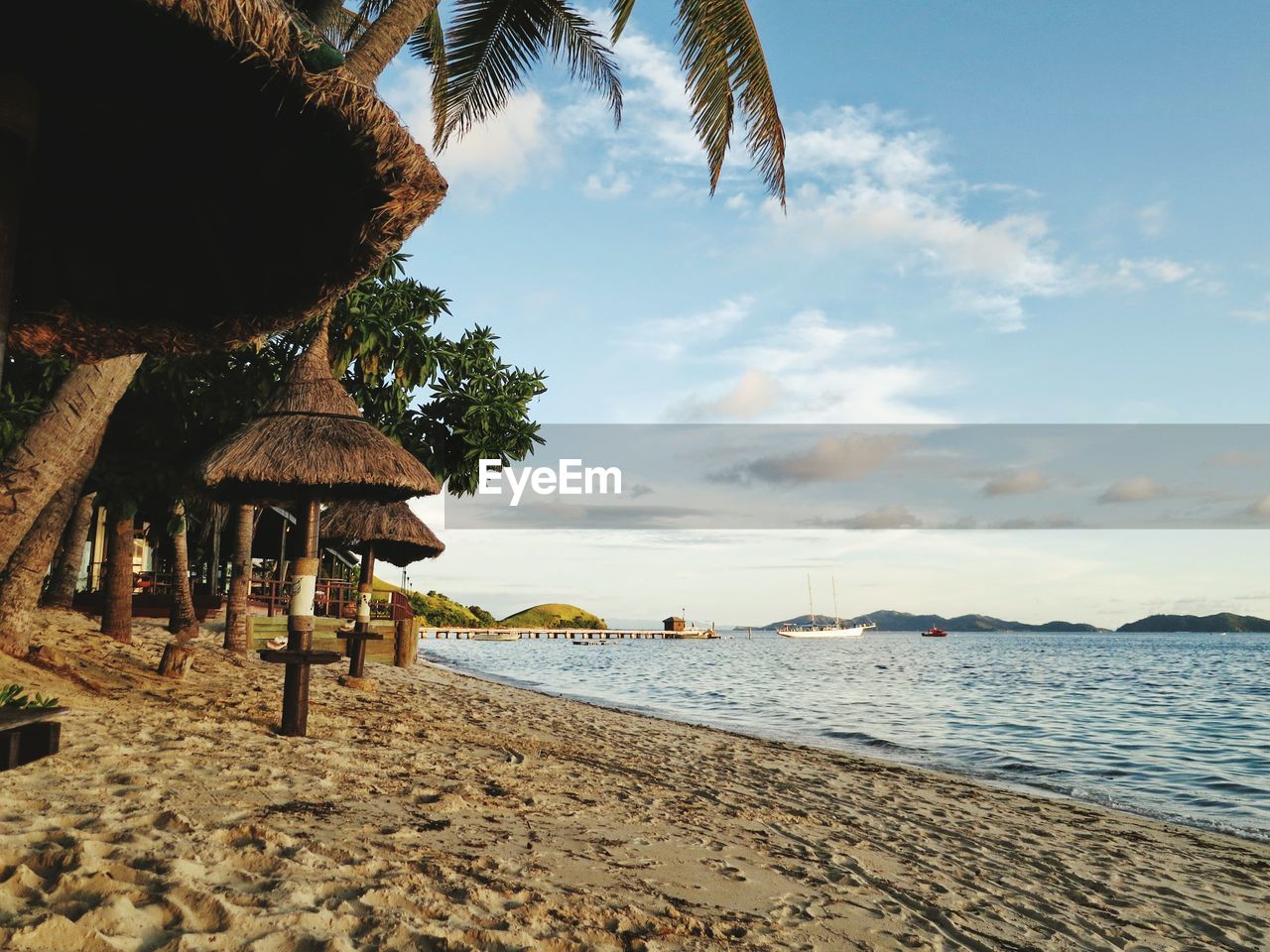 Thatched roof parasols on south beach by sea against sky in mana island