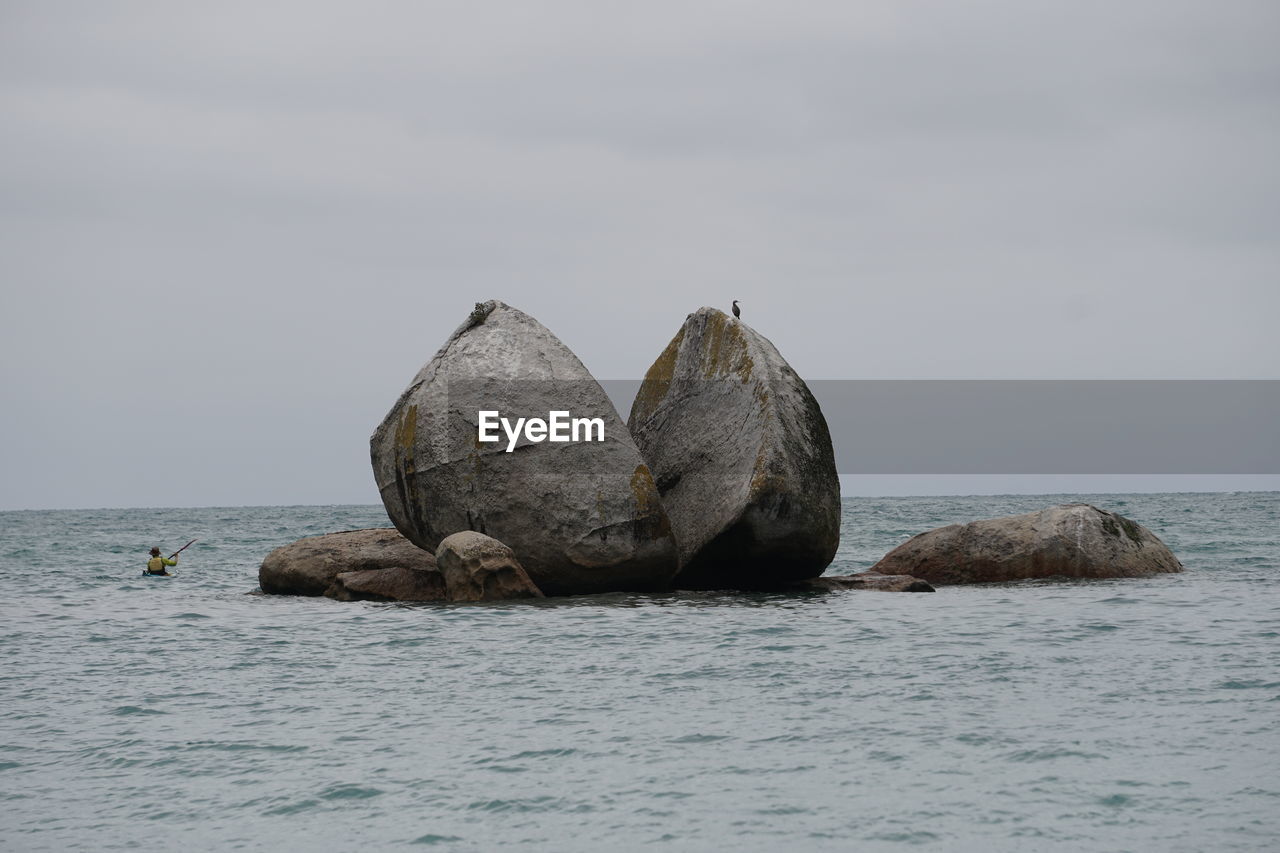 Rocks in sea against sky