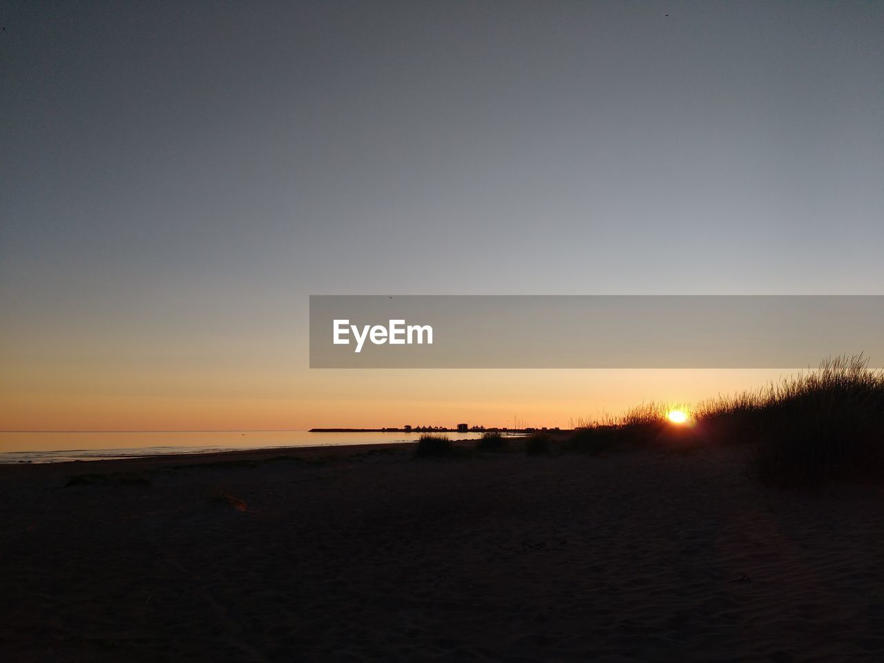 SCENIC VIEW OF BEACH AGAINST SKY DURING SUNSET