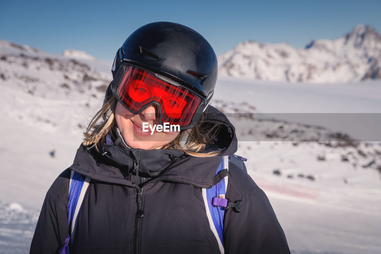 Woman skier on the slope of a mountain resort. portrait of a young woman smiling in ski equipment