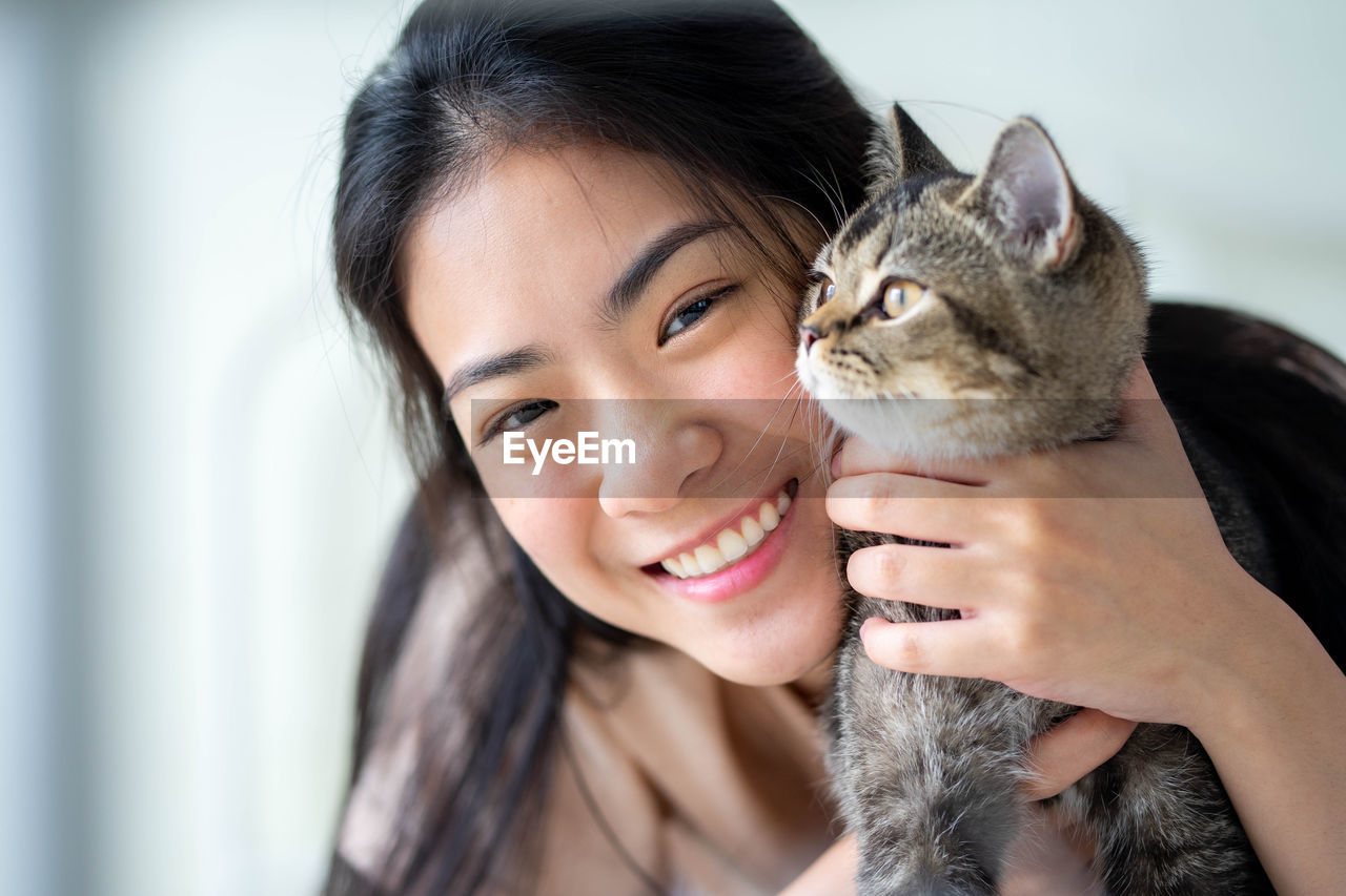 portrait of young woman with cat