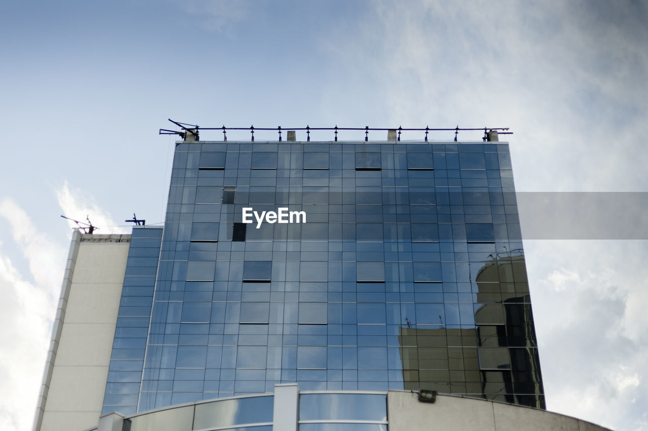 LOW ANGLE VIEW OF BIRDS FLYING OVER MODERN BUILDING