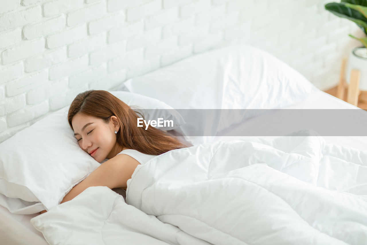 YOUNG WOMAN SLEEPING IN BED